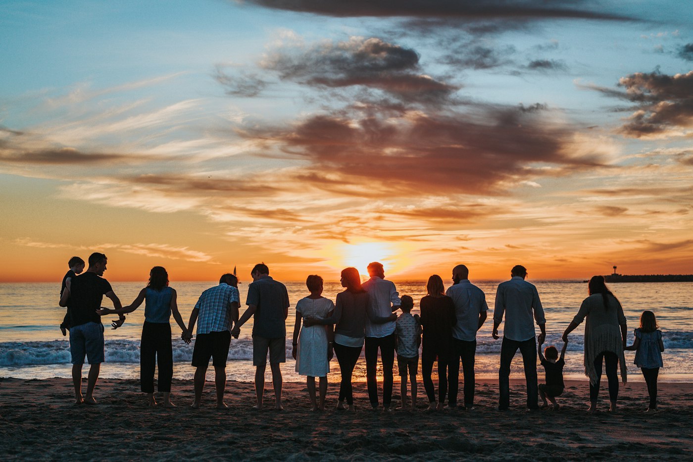 Family walking together on the beach at sunset